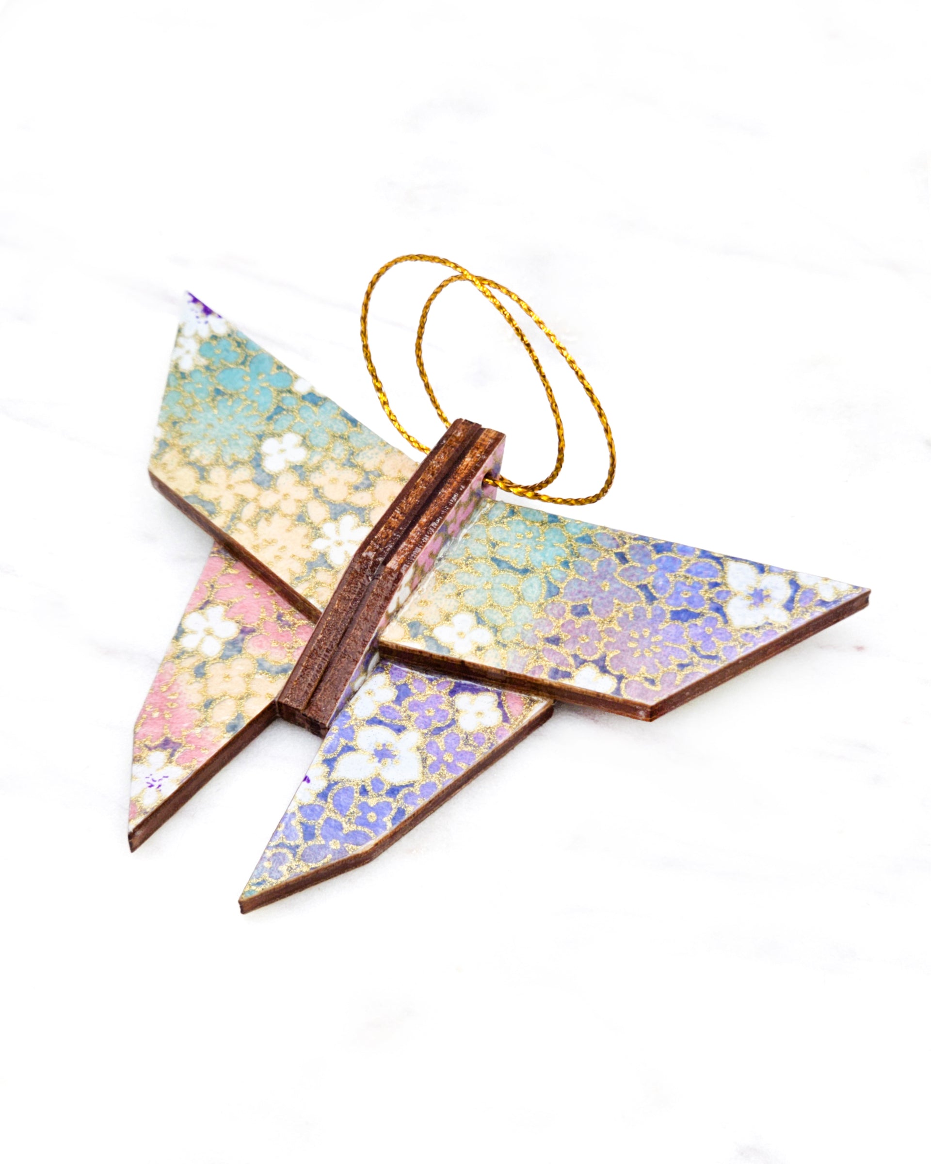 Small wooden origami butterfly ornament featuring small rainbow-colored flowers with metallic gold details.