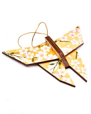 Wooden origami butterfly ornament featuring pink and white cherry blossoms on an orange background with metallic gold accents.