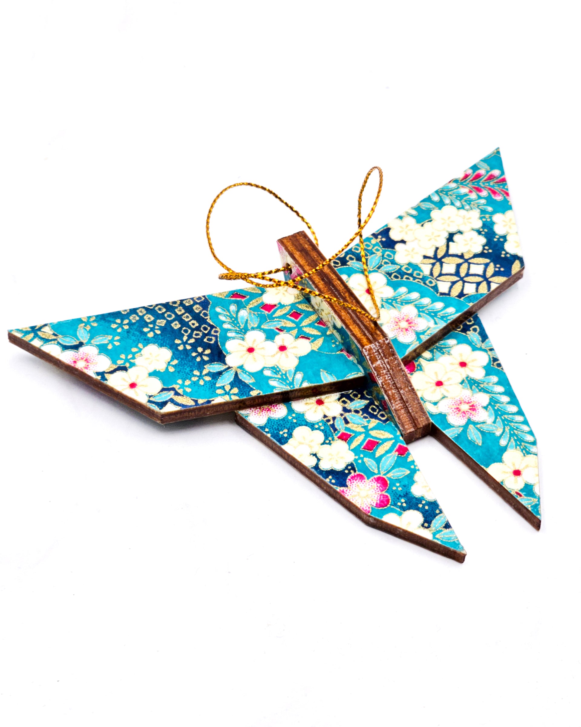 Wooden origami butterfly ornament featuring pink, white, and cream plum blossoms with blue wisteria on a teal and blue background with metallic gold accents.