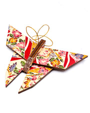 Wooden origami butterfly ornament featuring red floral ribbons on a beige background.