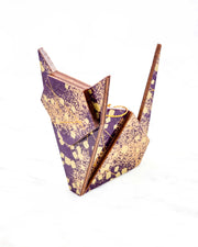 Large wooden origami cat ornament featuring scattered metallic gold geometric shapes and fine gold lines on a dark purple background.