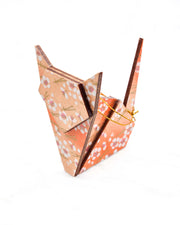 Large wooden origami cat ornament featuring small white plum blossoms and matsuba (pine needles) on an orange gradient background with metallic gold details.