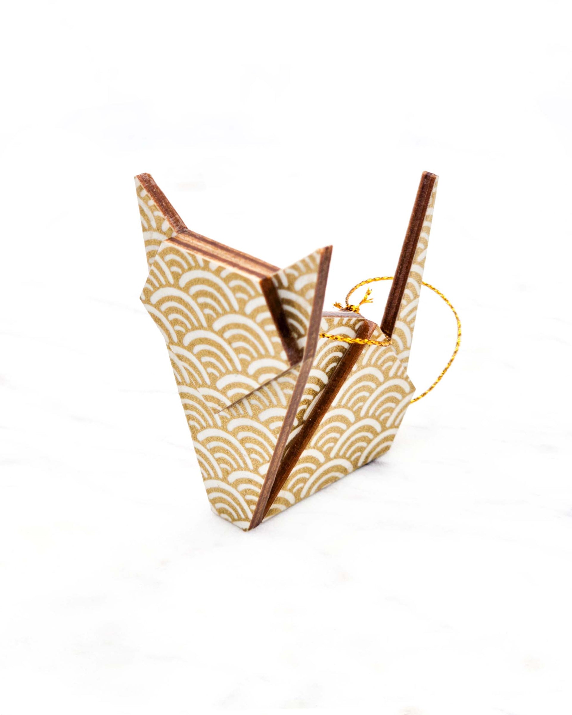 Small wooden origami cat ornament featuring a traditional white and metallic gold seigaiha (wave crests) pattern.