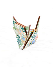 Small wooden origami cat ornament featuring green, white, blue, and pink cherry blossoms on a green background with metallic gold details.