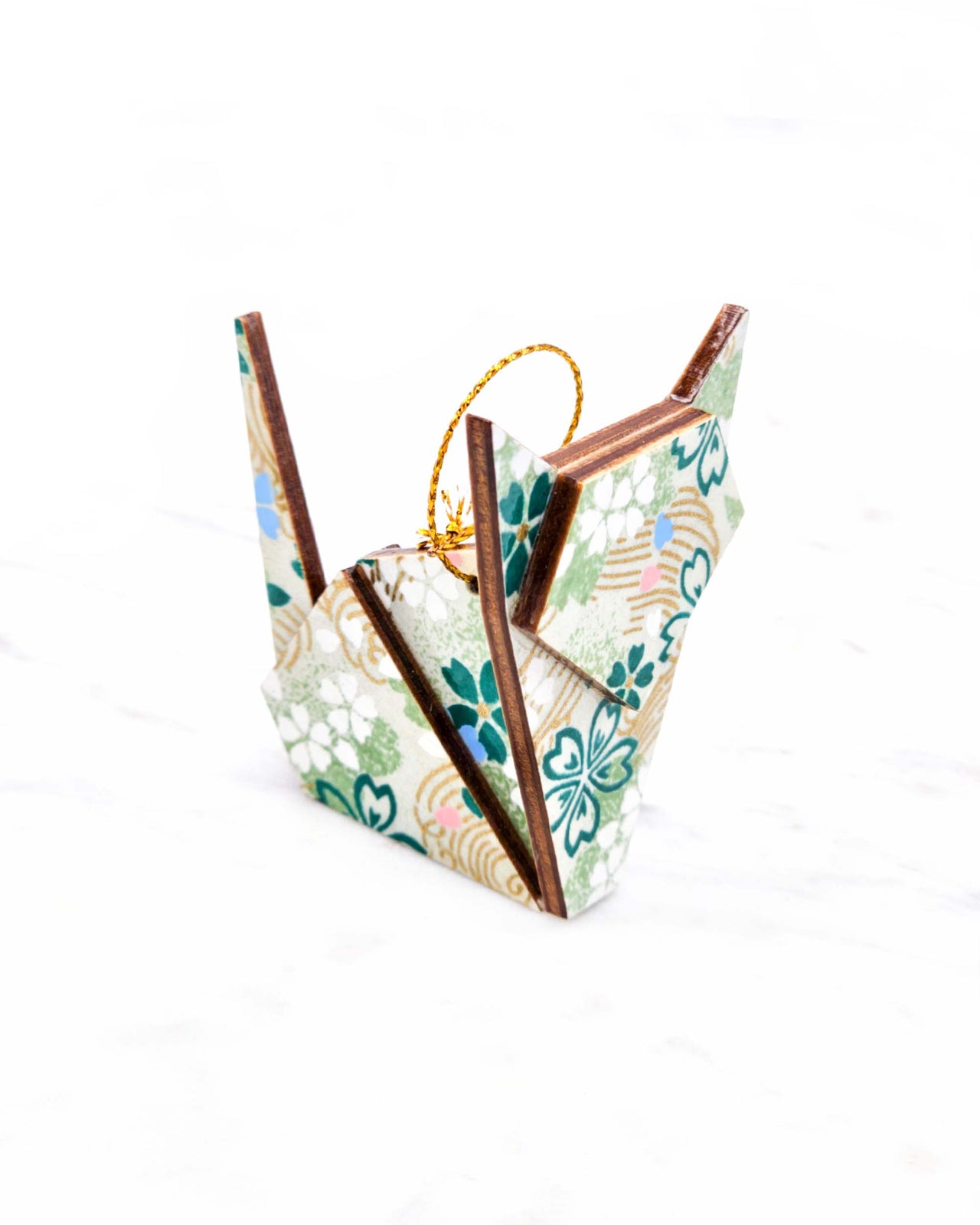 Small wooden origami cat ornament featuring green, white, blue, and pink cherry blossoms on a green background with metallic gold details.