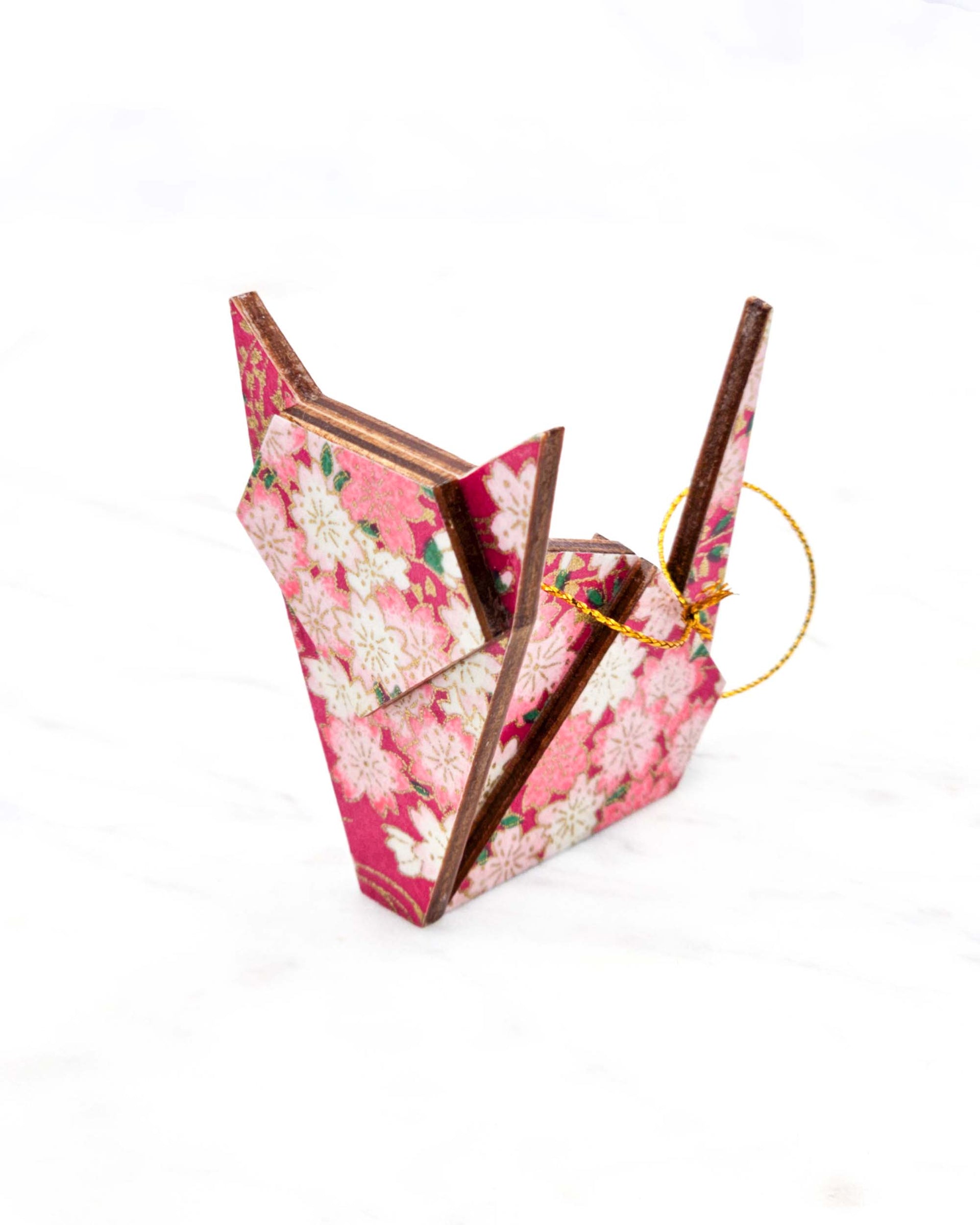 Small wooden origami cat ornament featuring pink and white cherry blossoms on a pink background with metallic gold details.