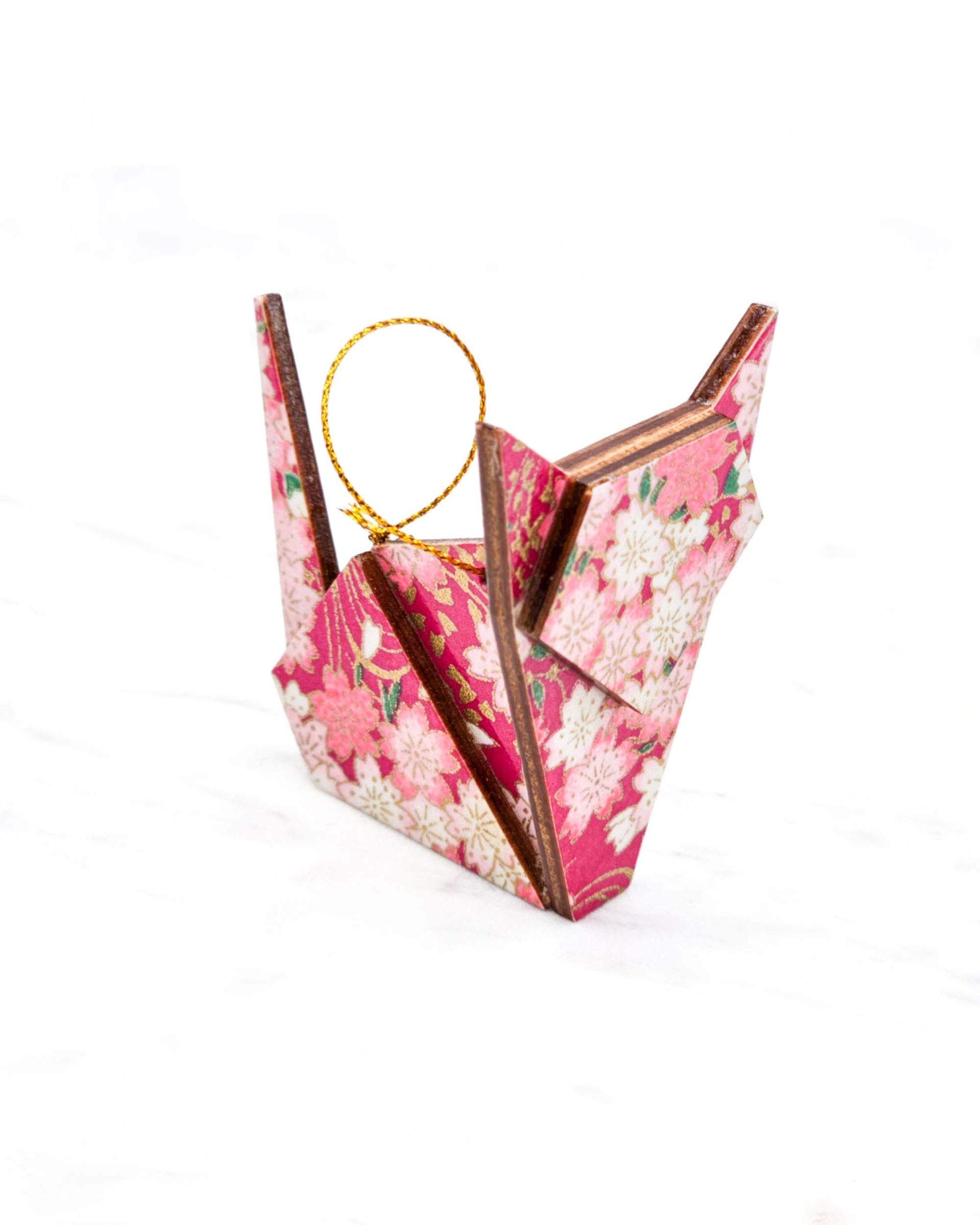 Small wooden origami cat ornament featuring pink and white cherry blossoms on a pink background with metallic gold details.