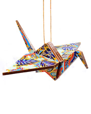 Wooden origami crane ornament featuring blue and red frond leaves on a blue background.