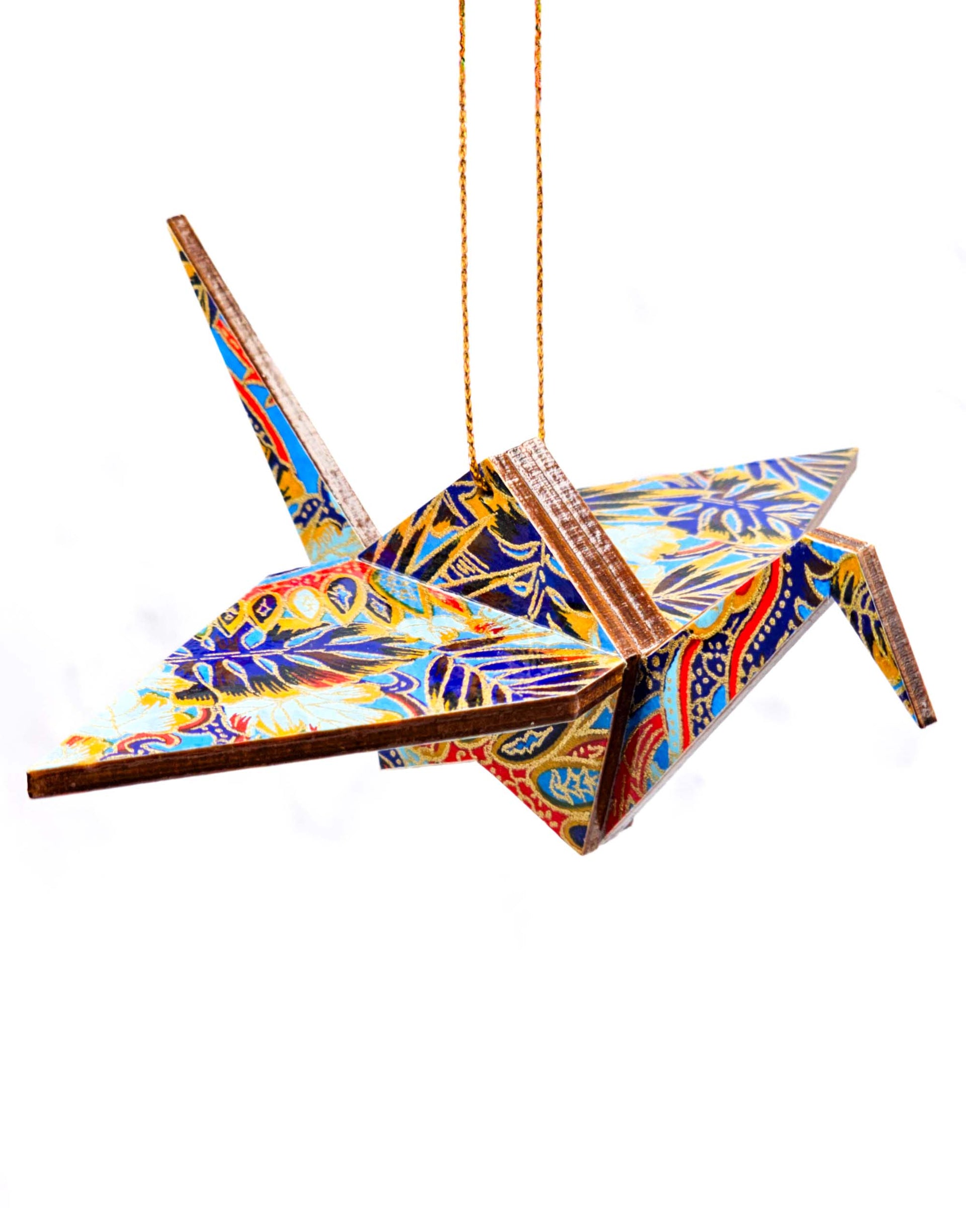 Wooden origami crane ornament featuring blue and red frond leaves on a blue background.