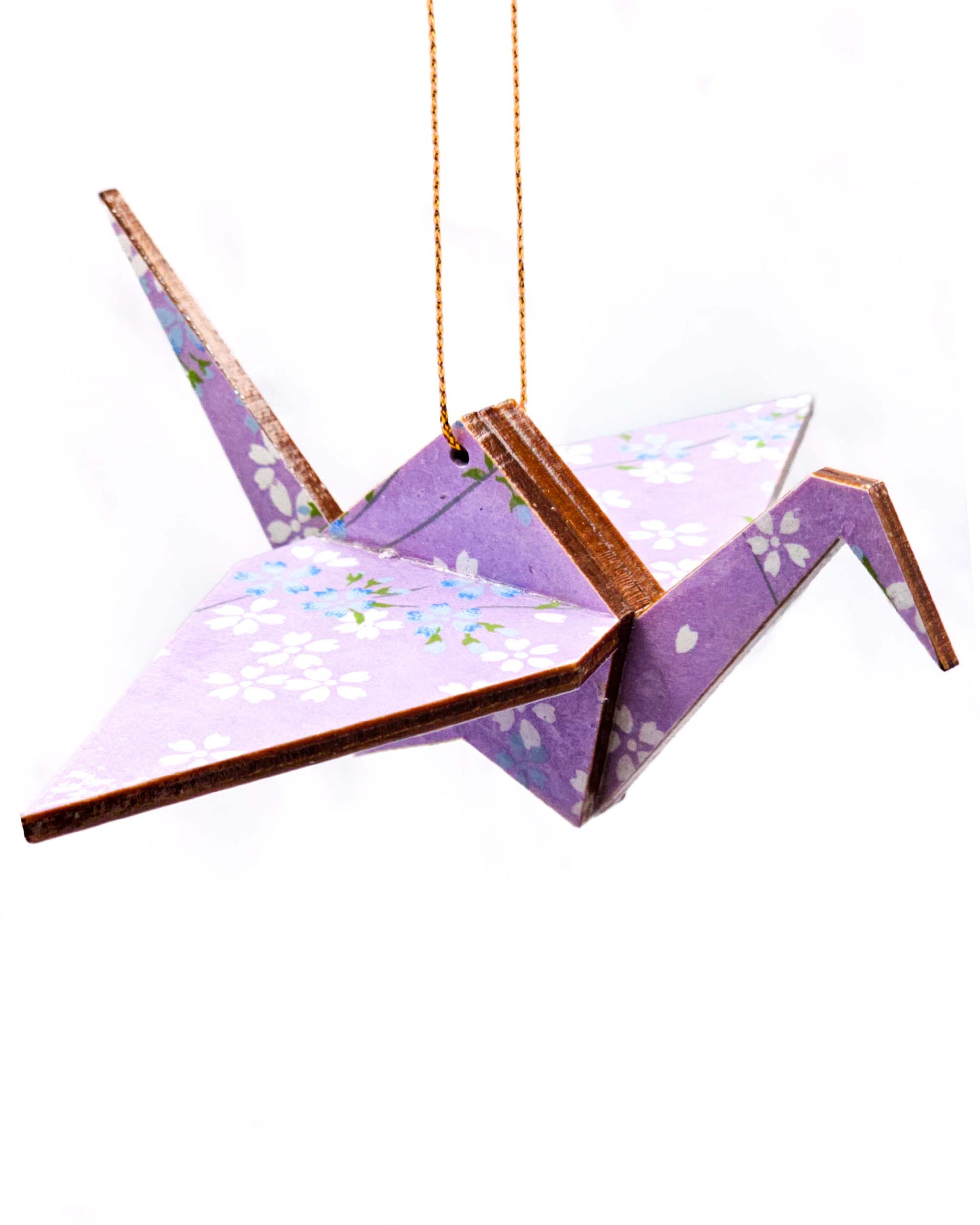 Wooden origami crane ornament featuring white and blue cherry blossoms on a light purple background.