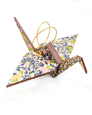 Large wooden origami crane ornament featuring yellow, pink, and green daffodil flowers on a gray background with metallic gold details.