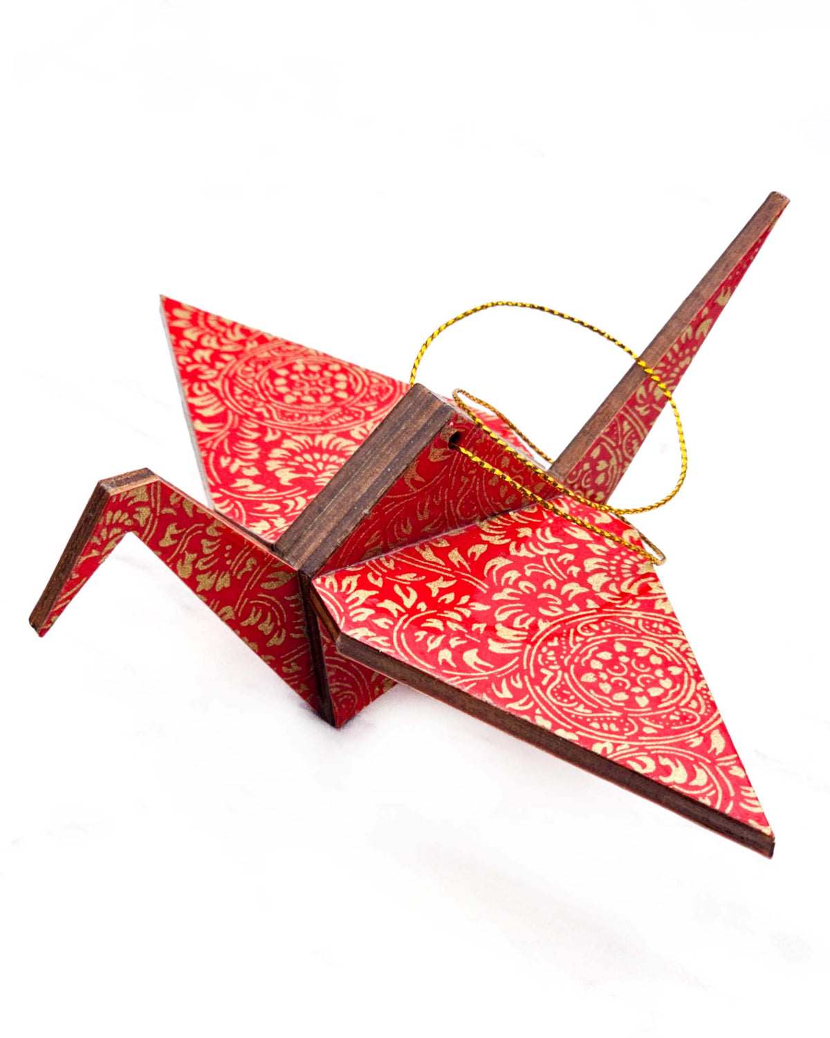 Large wooden origami crane ornament featuring metallic gold filigree circles on a red background.