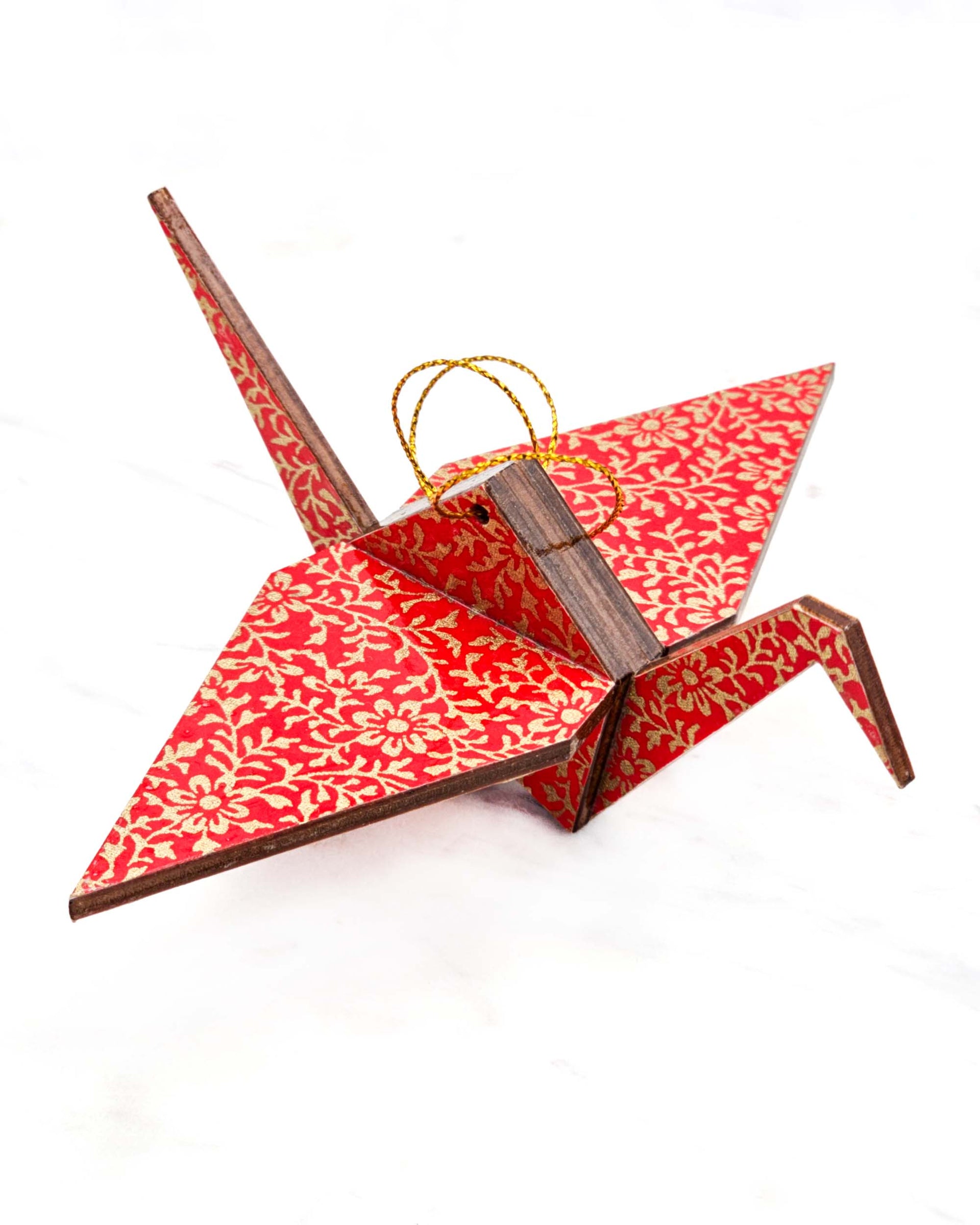 Large wooden origami crane ornament featuring a metallic gold floral motif on a bright red background.