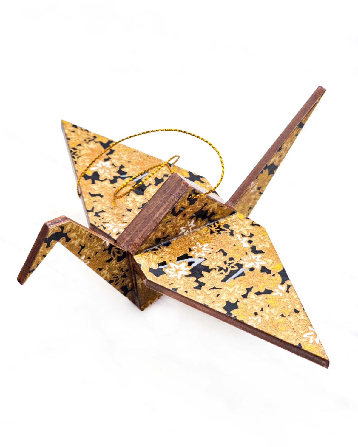 Large wooden origami crane ornament featuring small metallic gold and white momiji (maple leaves) on a black background.