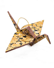 Large wooden origami crane ornament featuring small metallic gold and white momiji (maple leaves) on a black background.