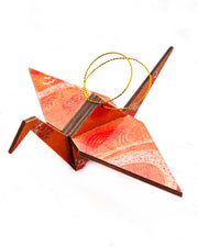 Large wooden origami crane ornament featuring orange swirls with metallic gold details.