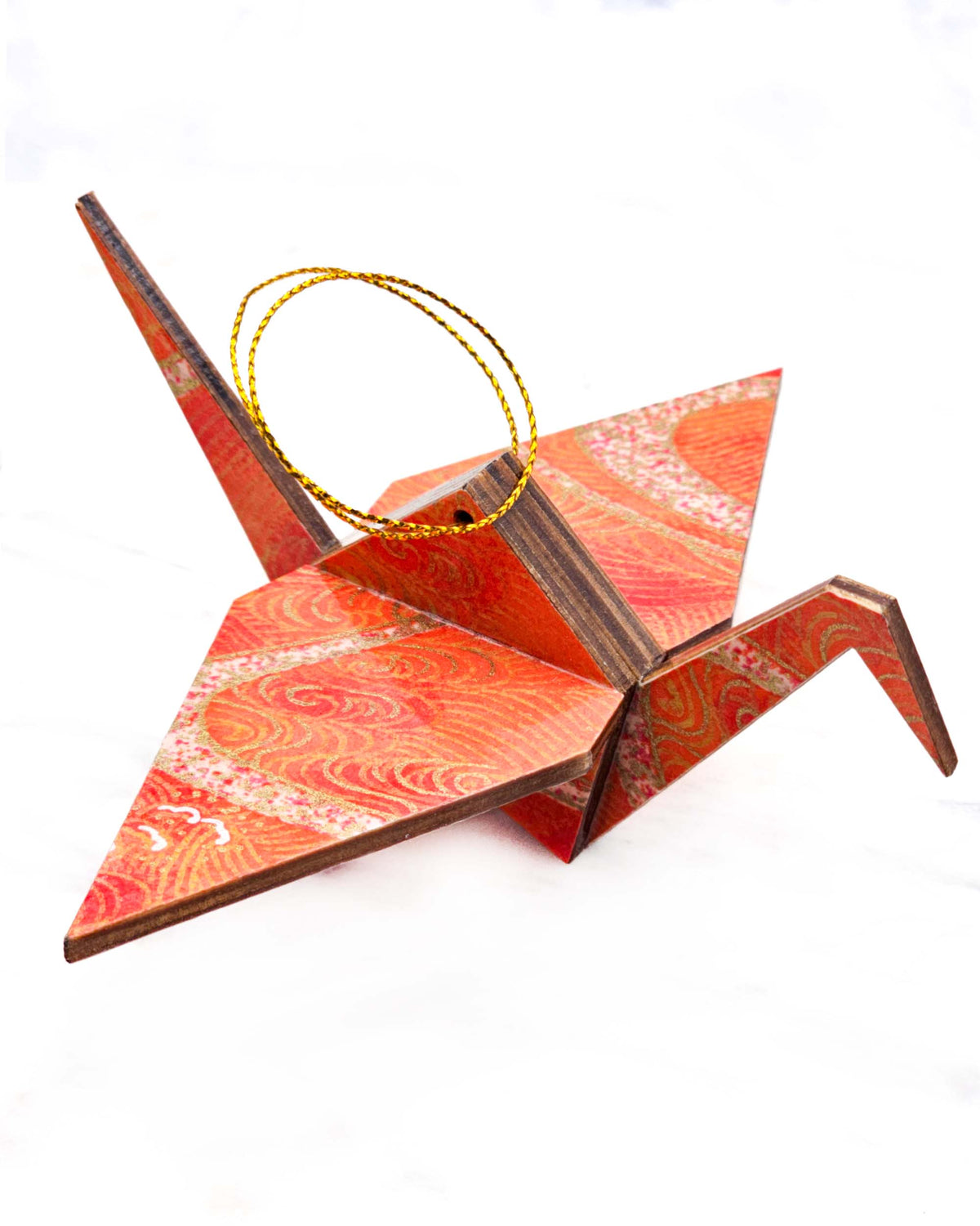 Large wooden origami crane ornament featuring orange swirls with metallic gold details.
