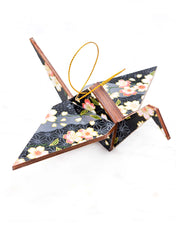 Large wooden origami crane ornament featuring pink and white cherry blossoms on a black and gray background with metallic gold accents.