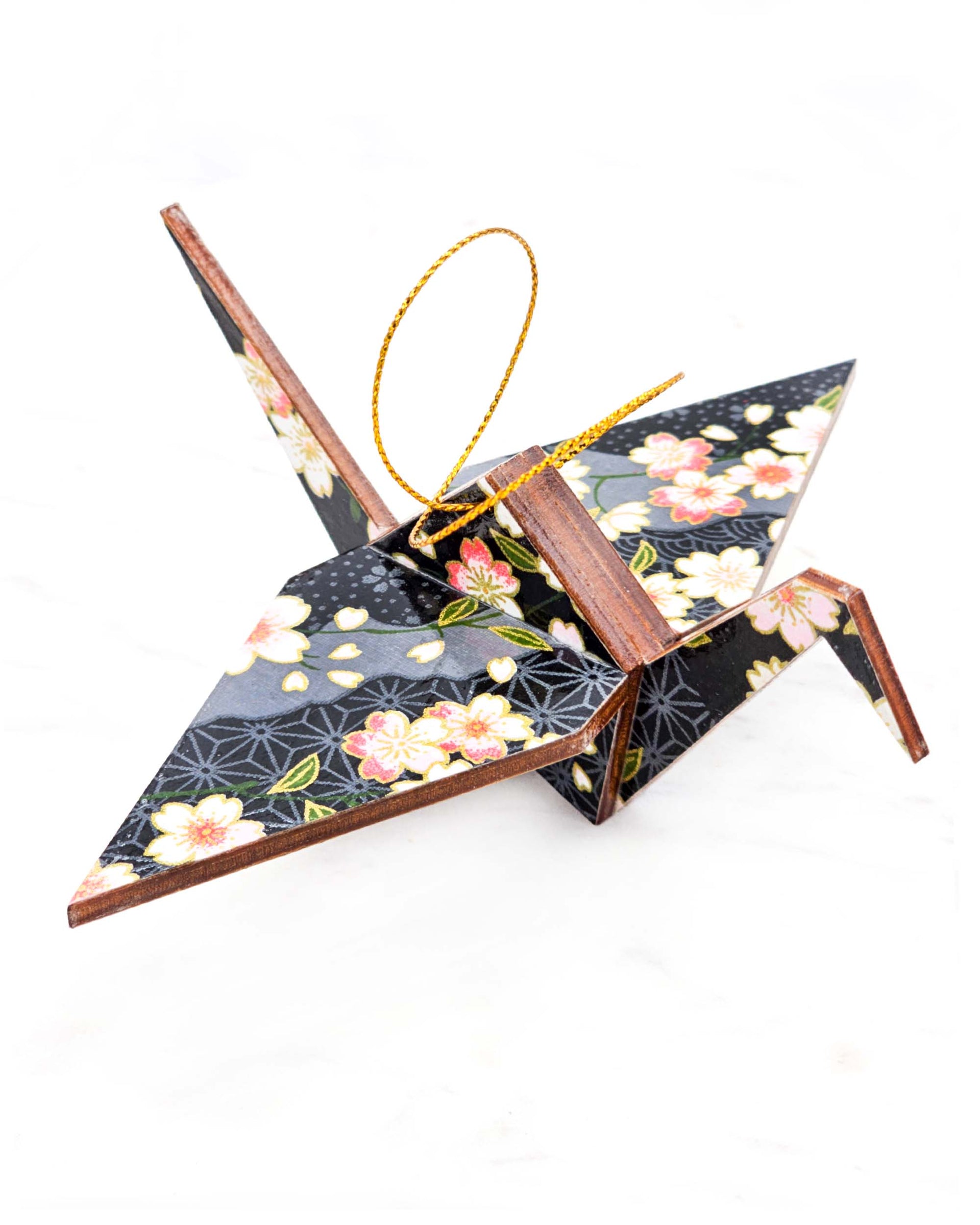Large wooden origami crane ornament featuring pink and white cherry blossoms on a black and gray background with metallic gold accents.