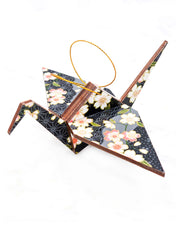 Large wooden origami crane ornament featuring pink and white cherry blossoms on a black and gray background with metallic gold accents.