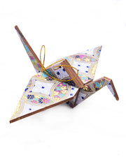 Large wooden origami crane ornament featuring a blue, yellow, and purple shippo design filled with assorted floral and geometric designs on a light purple background with metallic gold details.