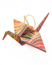 Large wooden origami crane ornament featuring colorful rolling hills in red, yellow, green, black, and gray with metallic gold details.