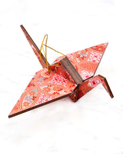 Large wooden origami crane ornament featuring a red, pink, and purple shippo design filled with assorted floral and geometric designs with metallic gold details. The centers of the shippos features assorted white floral outlines.