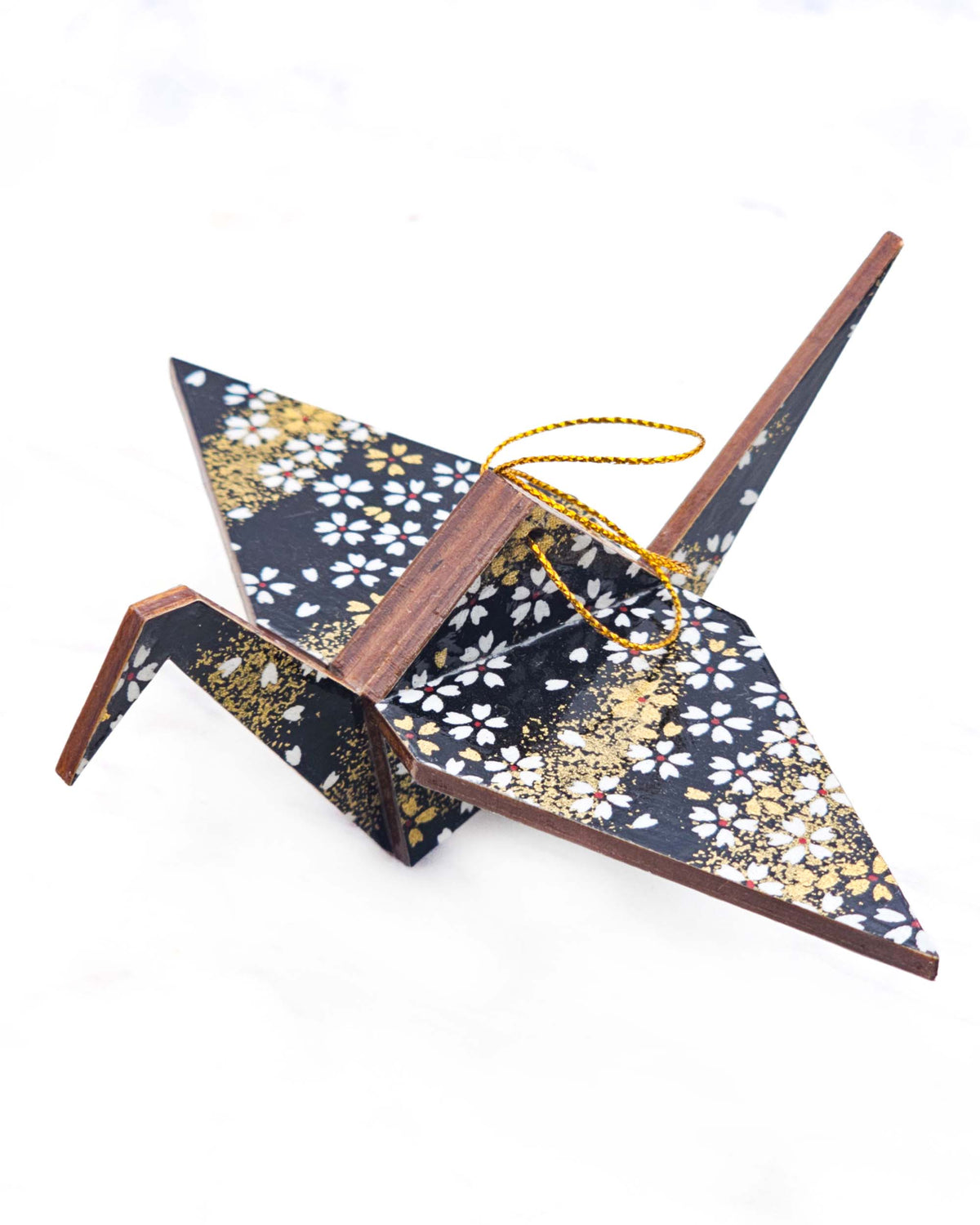 Large wooden origami crane ornament featuring small white and gold cherry blossoms on a black background with metallic gold details.