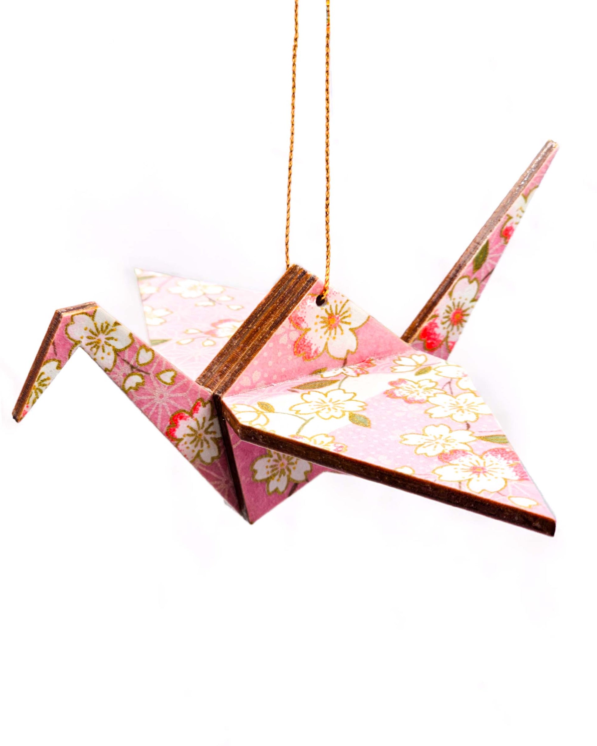 Wooden origami crane ornament featuring pink and white cherry blossoms on a light pink background with metallic gold accents.