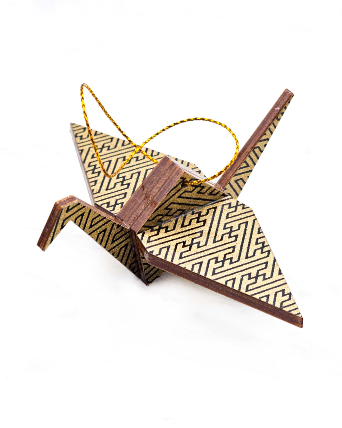 Small wooden origami crane ornament featuring a black traditional Japanese sayagata design on a metallic gold background.