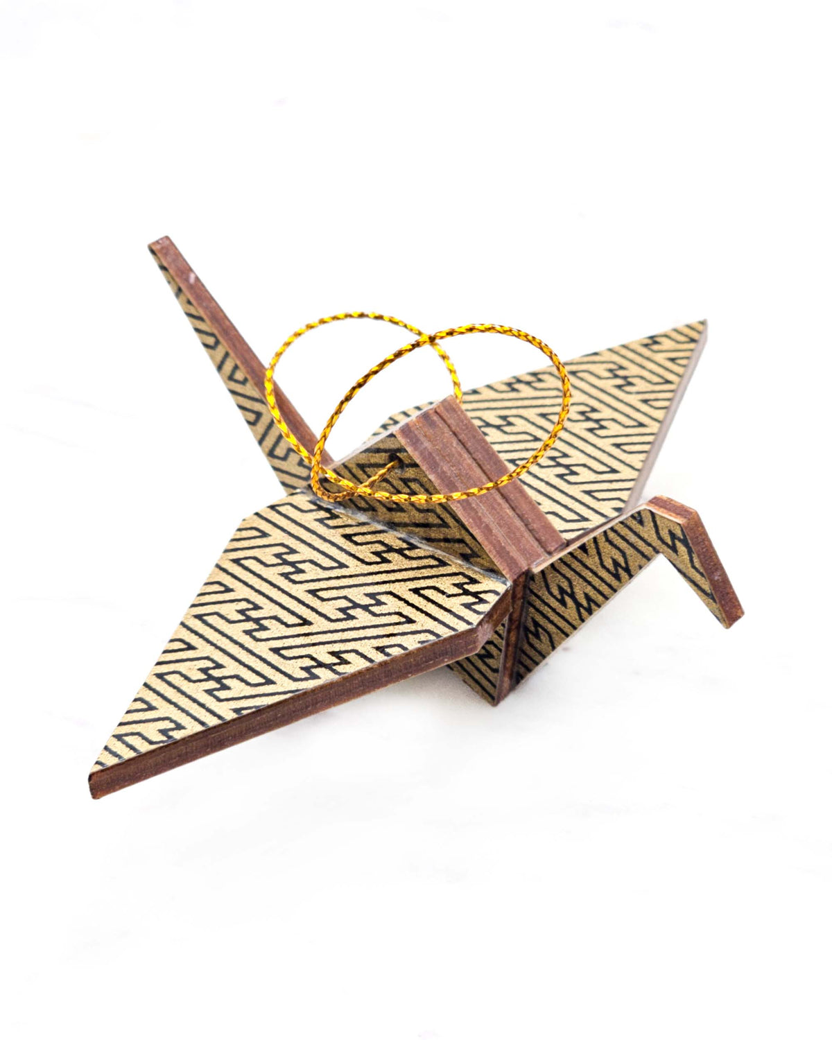 Small wooden origami crane ornament featuring a black traditional Japanese sayagata design on a metallic gold background.