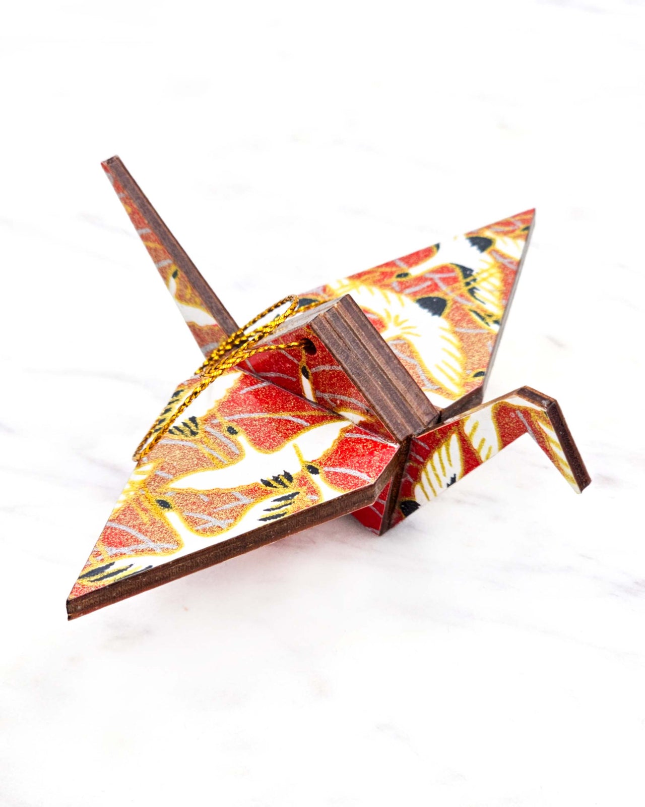 Small wooden origami crane ornament featuring white flying cranes on a red background with metallic gold accents.