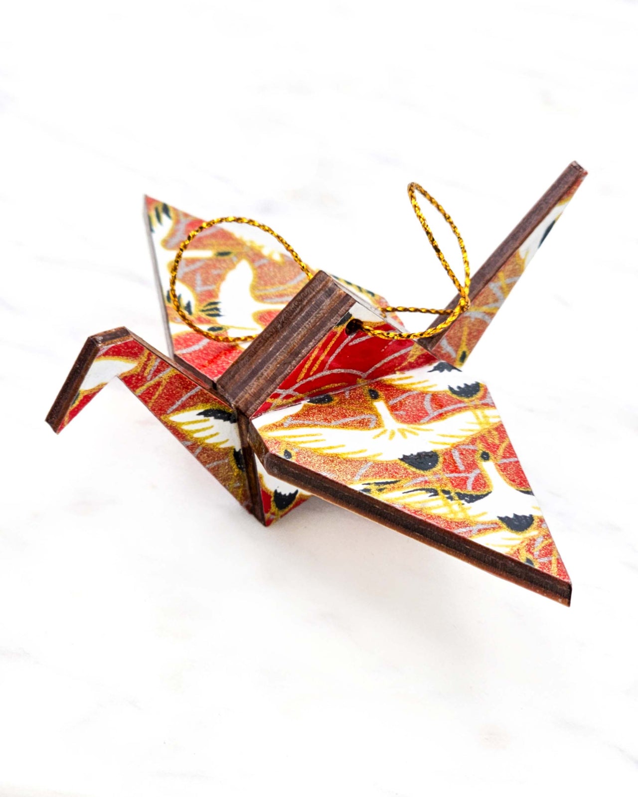 Small wooden origami crane ornament featuring white flying cranes on a red background with metallic gold accents.