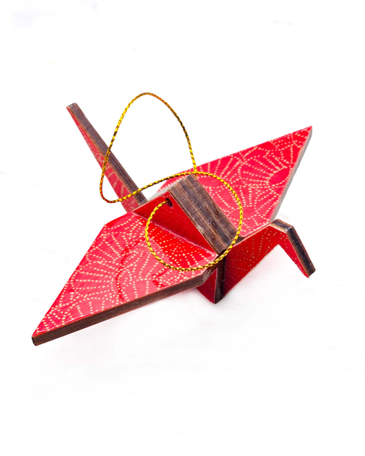 Small wooden origami crane ornament featuring metallic gold pointillistic temari balls on a red background.