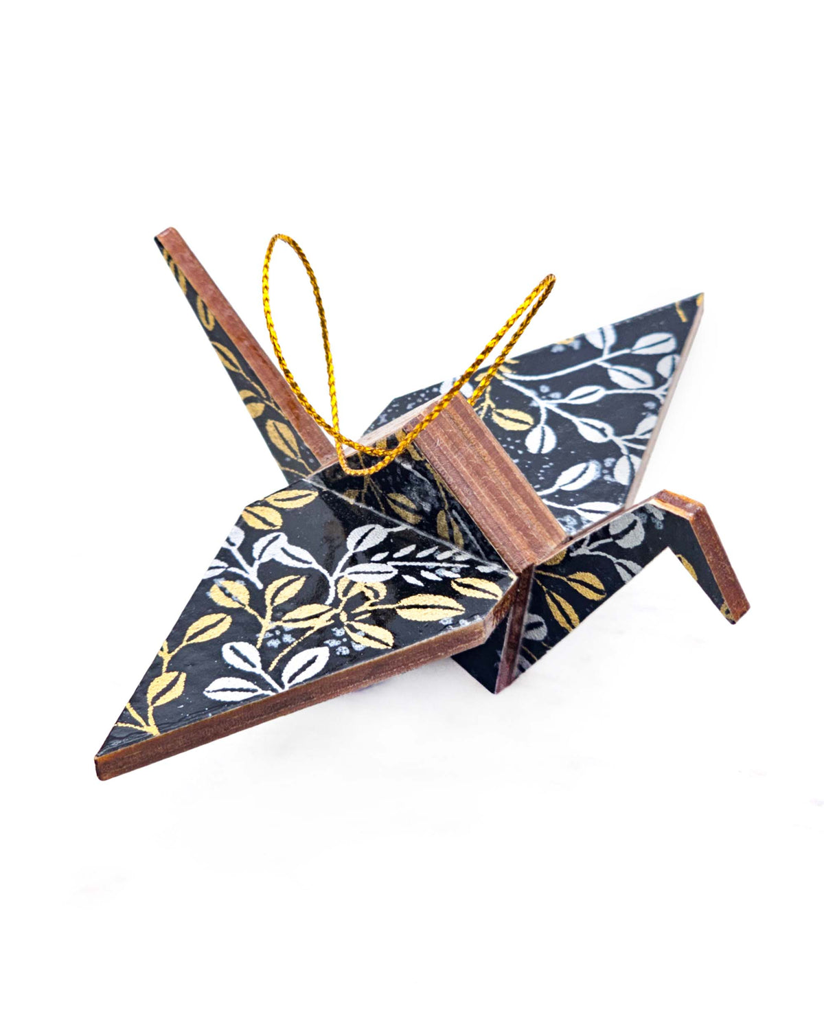Small wooden origami crane ornament featuring metallic gold and silver hagi (bush clover) on a black background.
