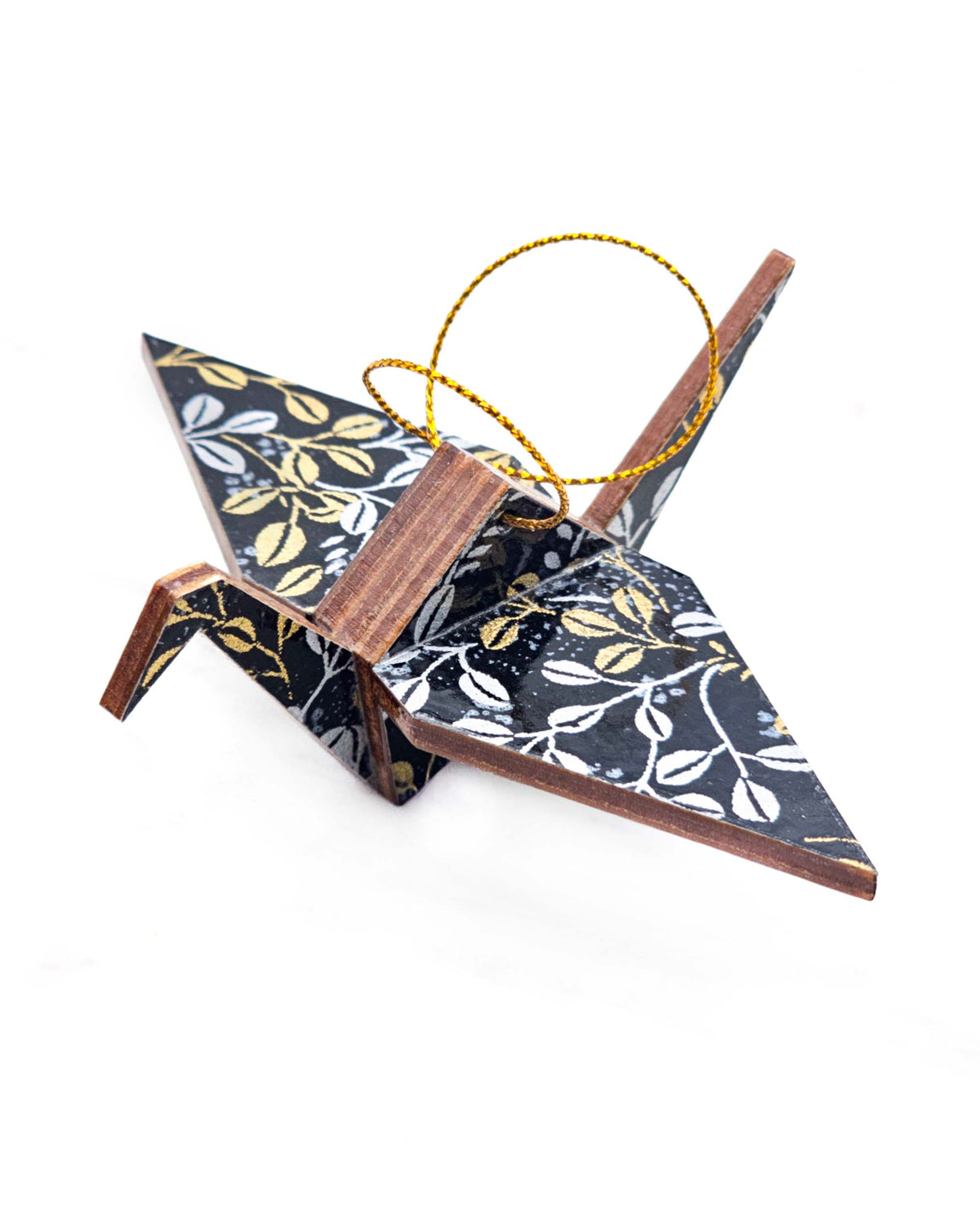 Small wooden origami crane ornament featuring metallic gold and silver hagi (bush clover) on a black background.
