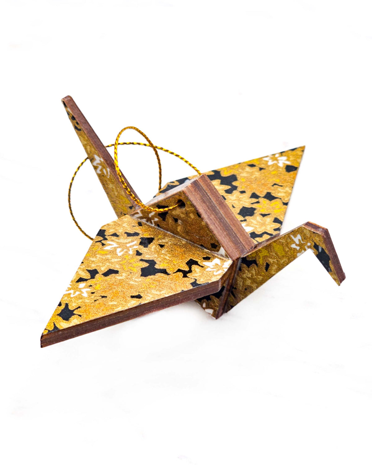 Small wooden origami crane ornament featuring small metallic gold and white momiji (maple leaves) on a black background.