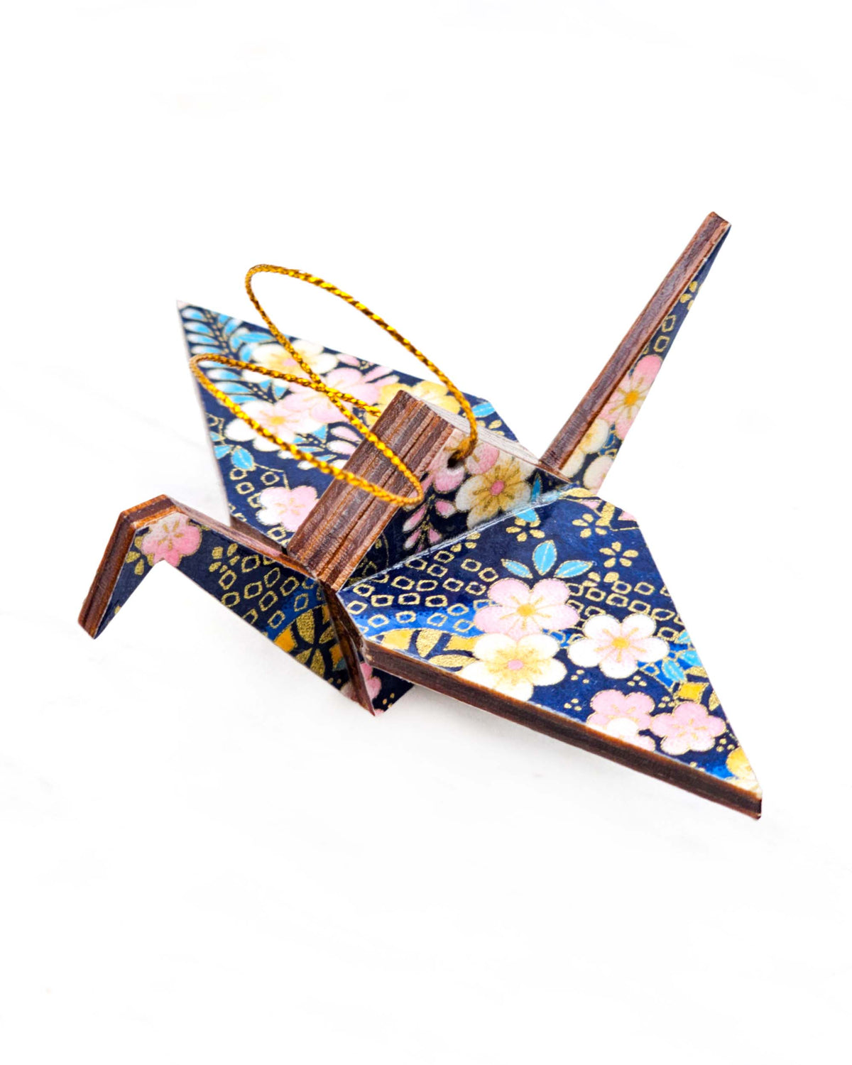 Small wooden origami crane ornament featuring pink and yellow plum blossoms and blue, pink, and yellow wisteria on a dark blue background with metallic gold details.