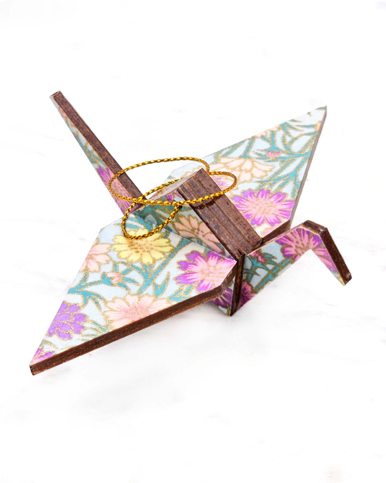 Small wooden origami crane ornament featuring white and pink cherry blossoms on a dark blue background with metallic gold accents.
