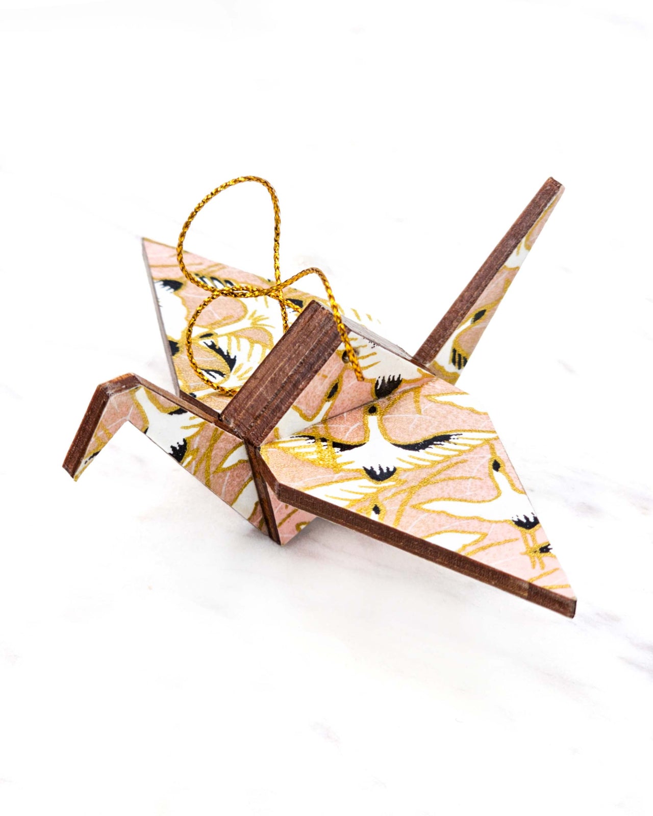 Small wooden origami crane ornament featuring white flying cranes on a light pink background with metallic gold accents.