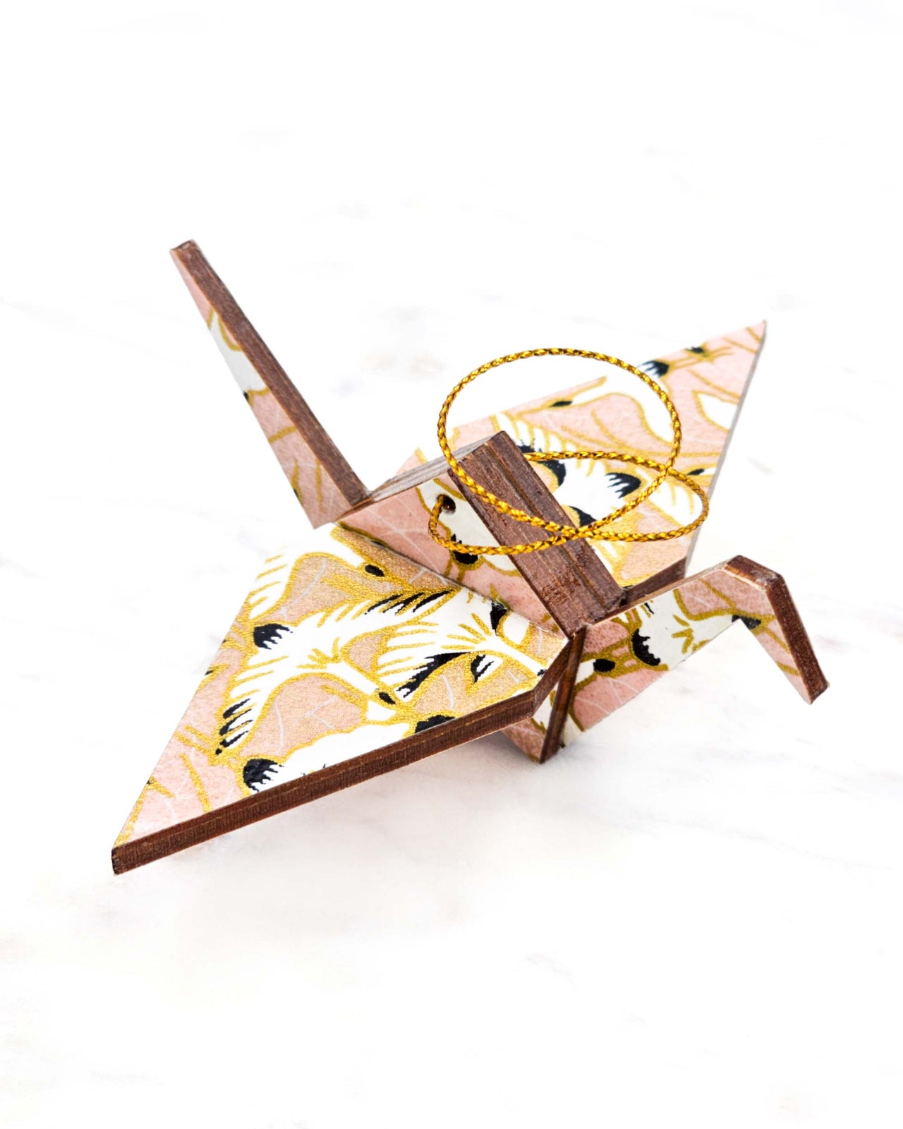 Small wooden origami crane ornament featuring white flying cranes on a light pink background with metallic gold accents.