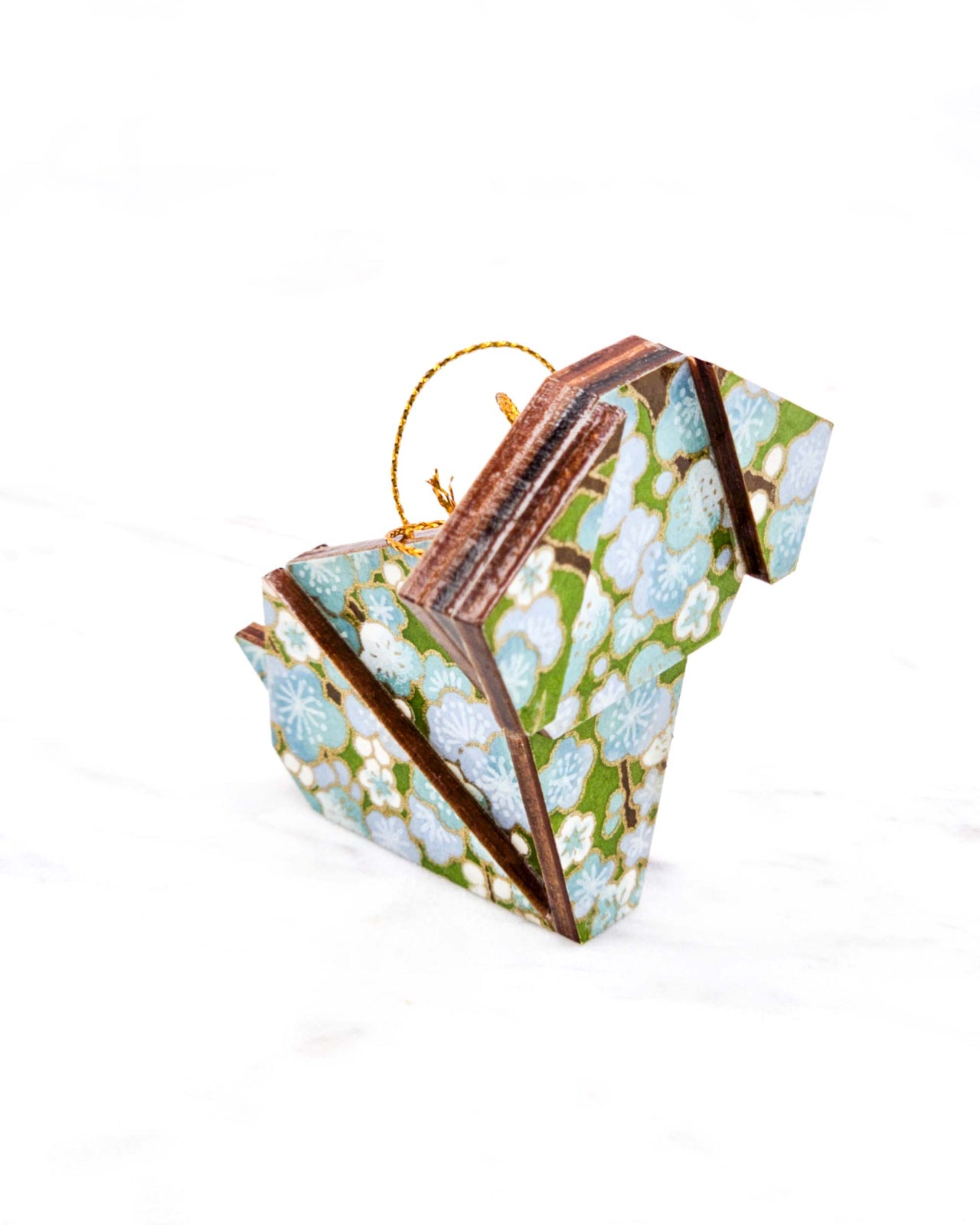 Small wooden origami dog ornament featuring light blue and white plum blossoms with brown branches on a green background with metallic gold details.