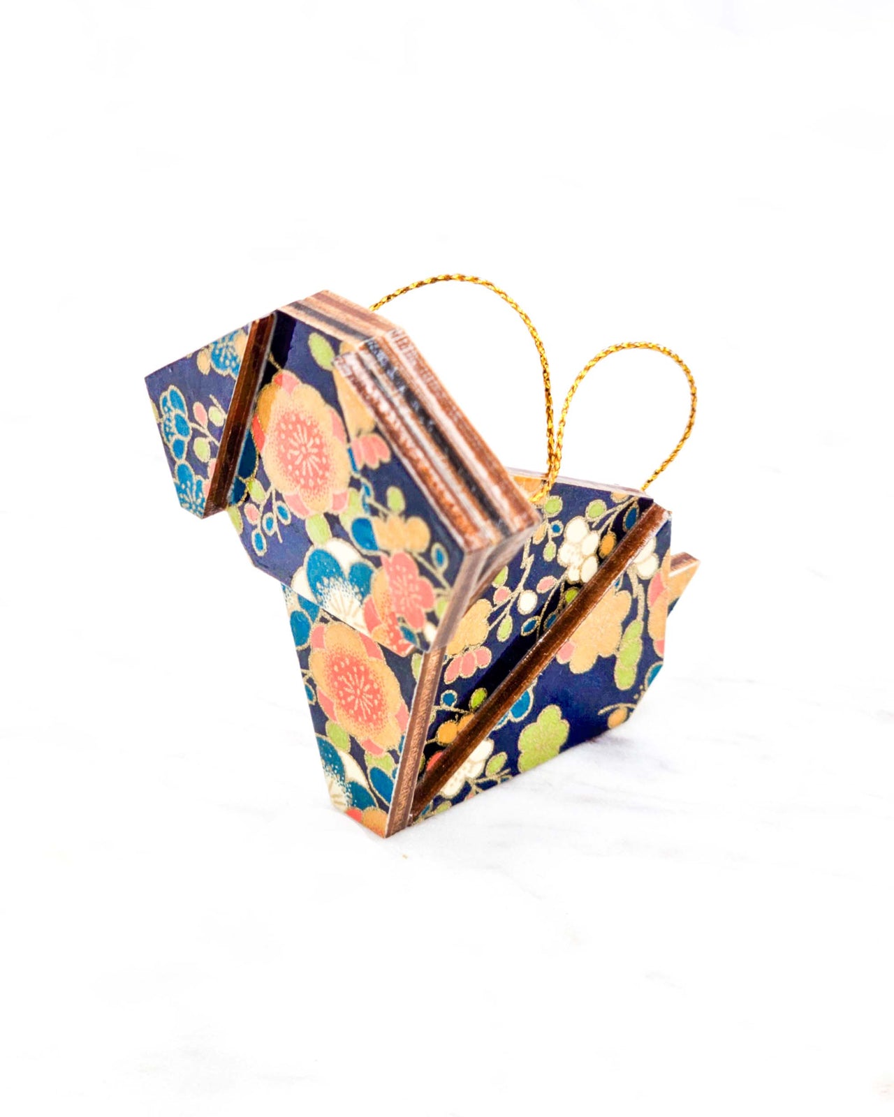 Small wooden origami dog ornament featuring orange, blue, green, and cream plum blossoms on a dark blue background with metallic gold details.