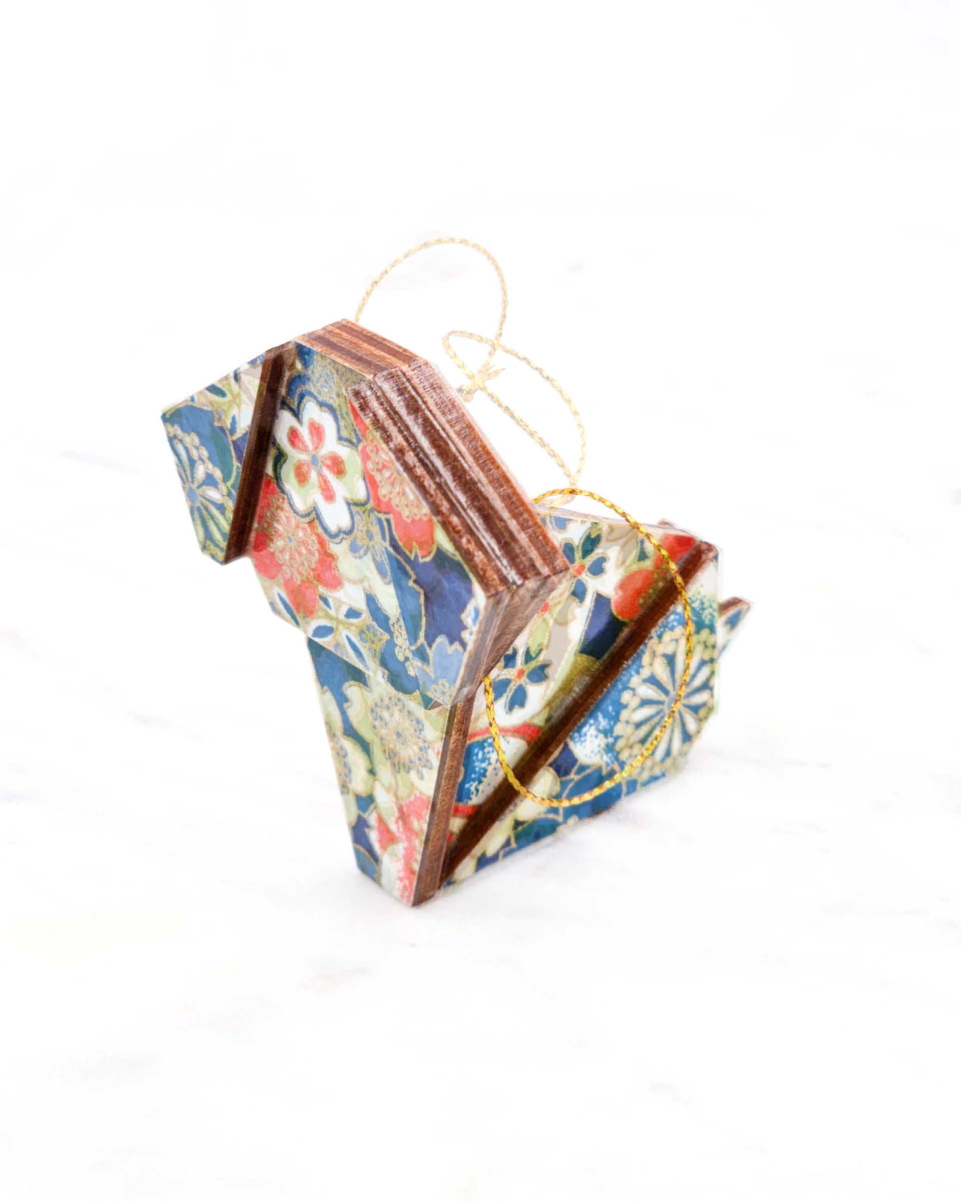 Small wooden origami dog ornament featuring red, white, and blue cherry blossoms with metallic gold details.
