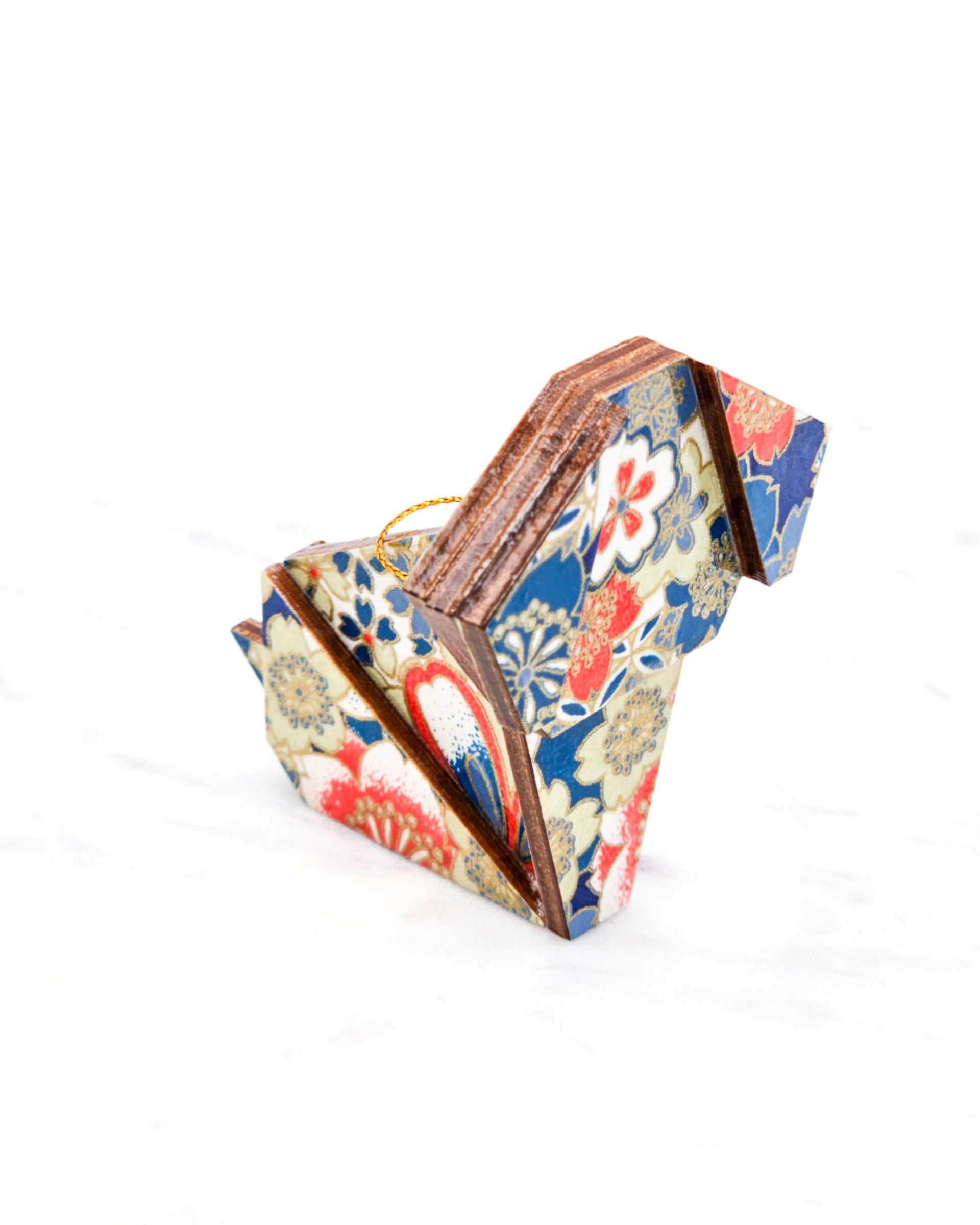 Small wooden origami dog ornament featuring red, white, and blue cherry blossoms with metallic gold details.