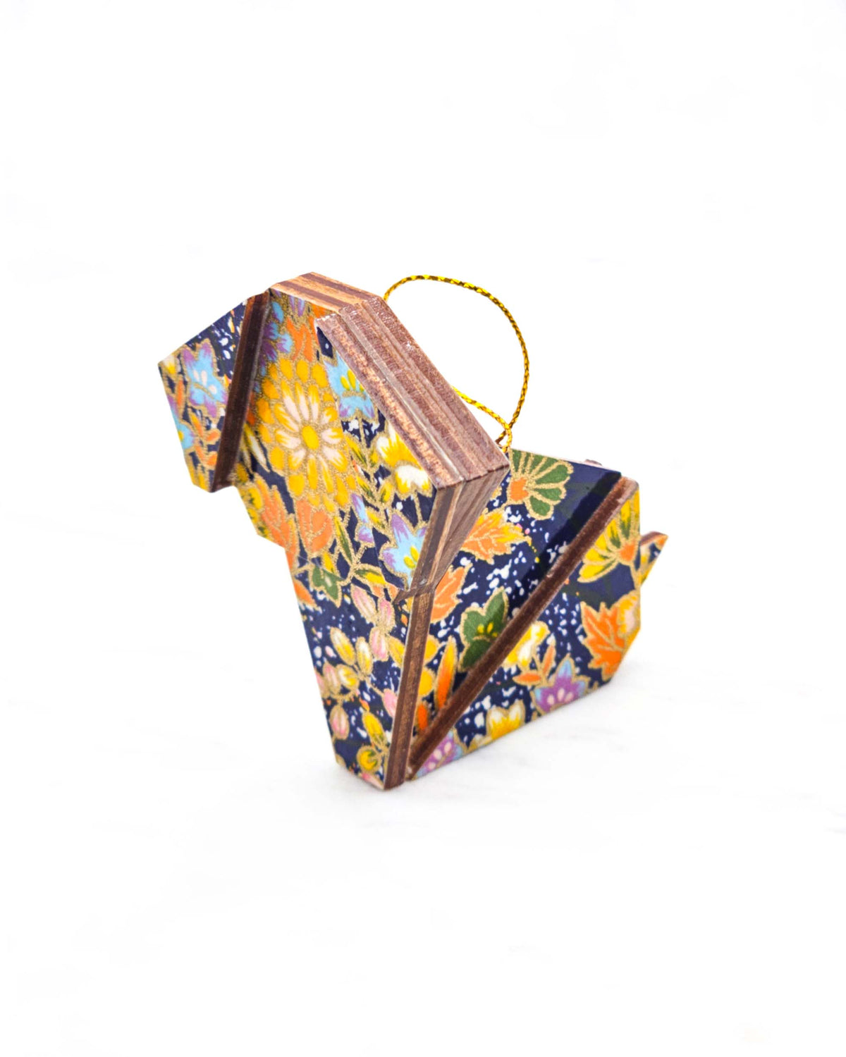 Small wooden origami dog ornament featuring an assortment of blue, yellow, orange, and green flowers on a dark blue background with metallic gold details.