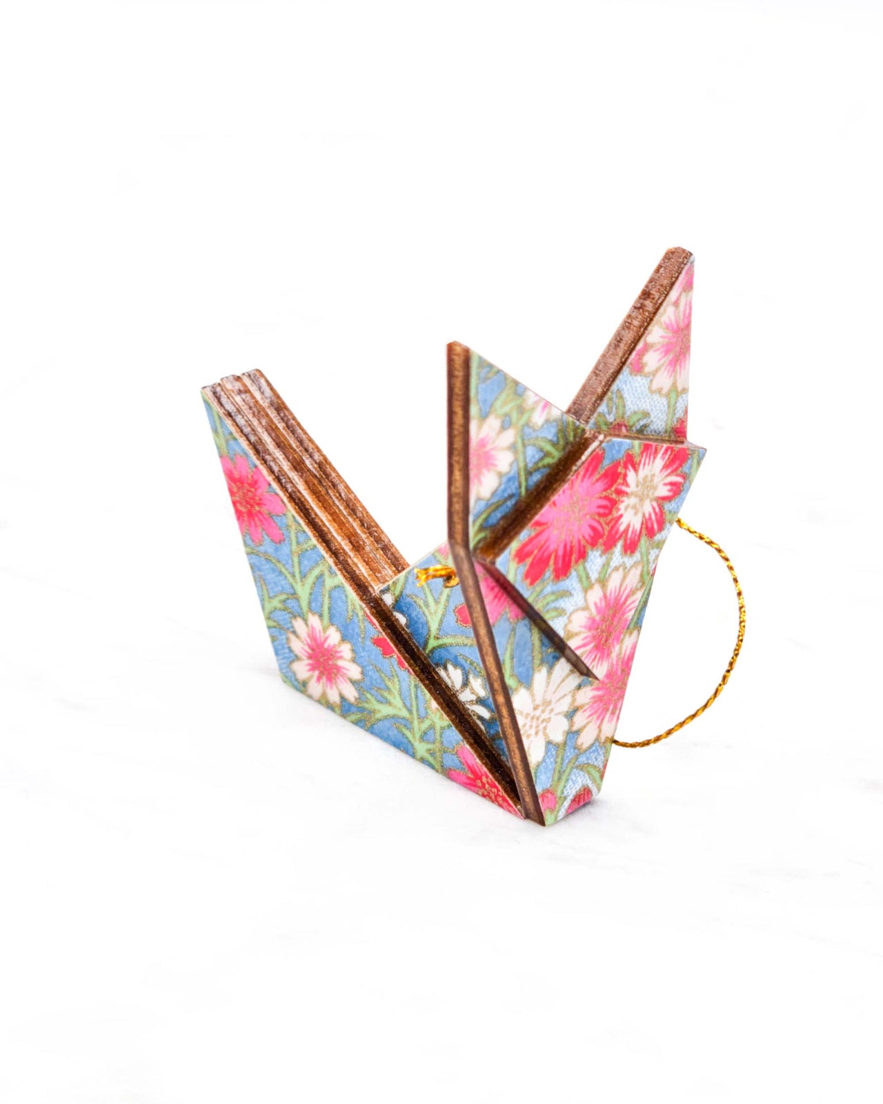 Small wooden origami fox ornament featuring pink and white flowers with green stems on a blue background with metallic gold details.