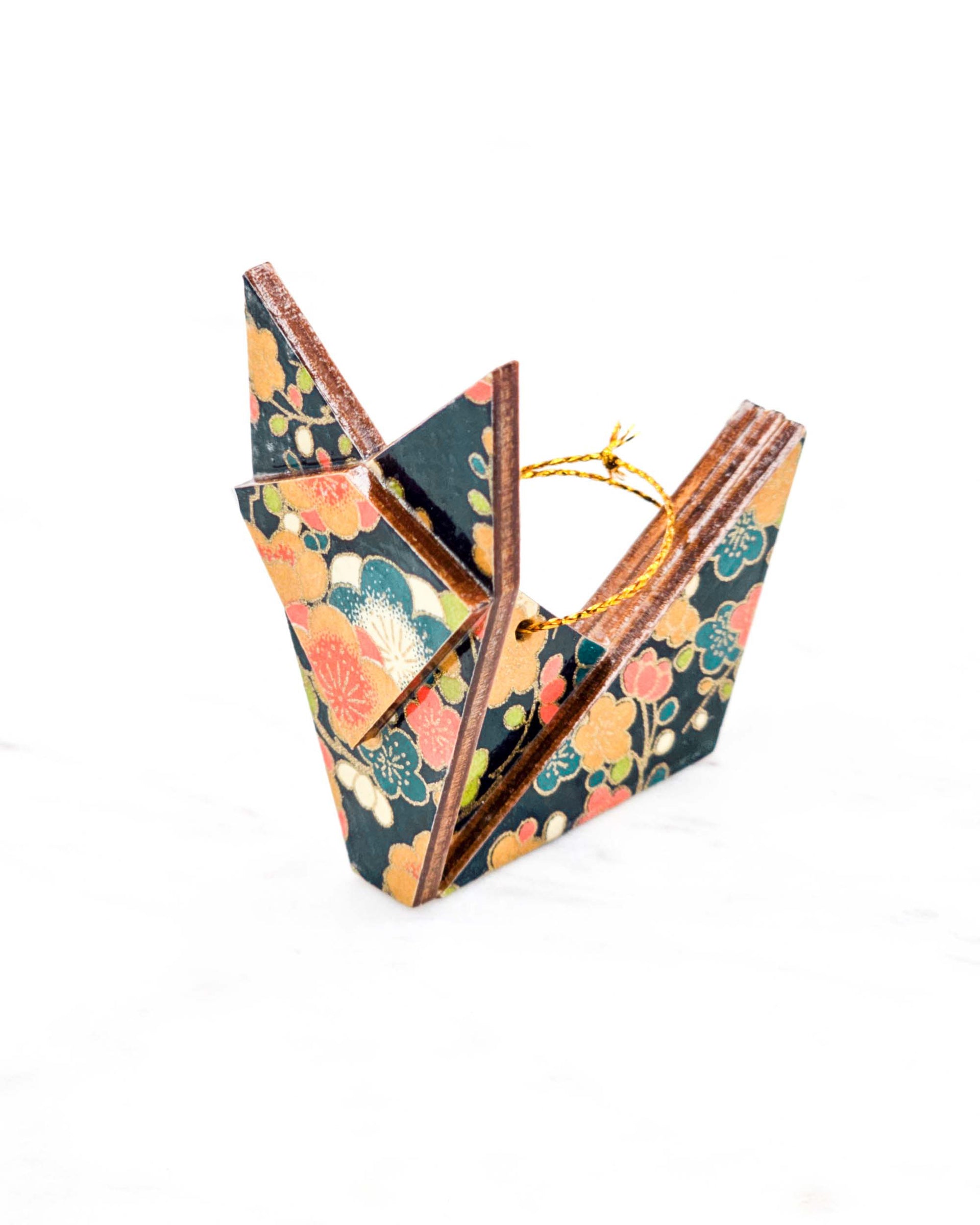 Small wooden origami fox ornament featuring orange, blue, green, and cream plum blossoms on a dark blue background with metallic gold details.