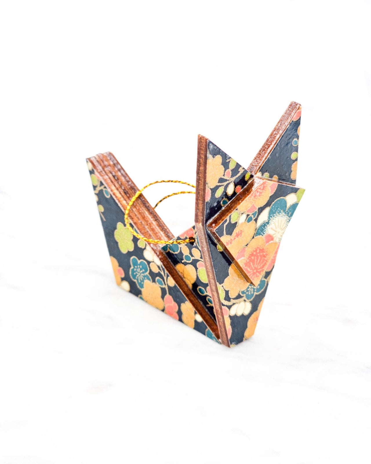 Small wooden origami fox ornament featuring orange, blue, green, and cream plum blossoms on a dark blue background with metallic gold details.
