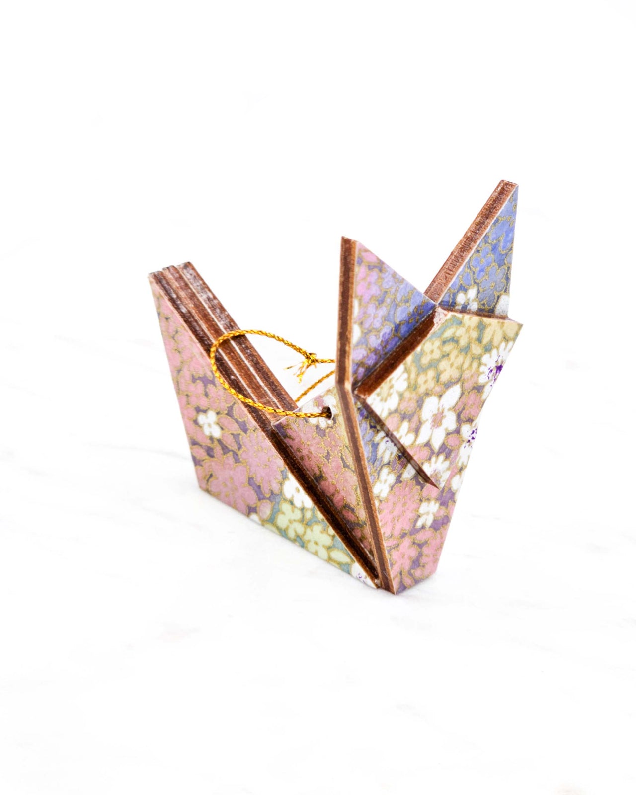 Small wooden origami fox ornament featuring small rainbow-colored flowers with metallic gold details.